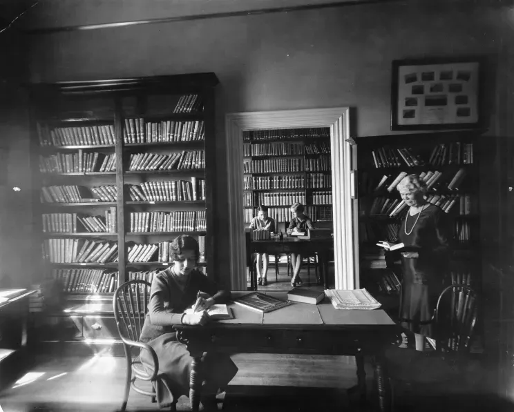 Historic image of female UNE students studying in library